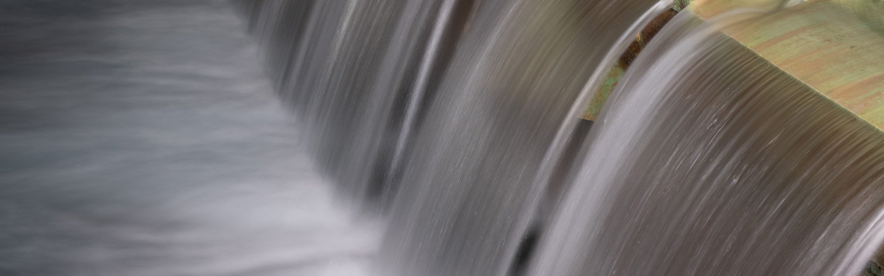 Piccole cascate di acqua che riempiono una grande vasca all'interno della struttura acea dell'acquedotto del peschiera