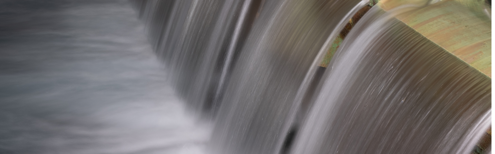 small waterfalls that fill a large basin inside the structure of the fishpond aqueduct
