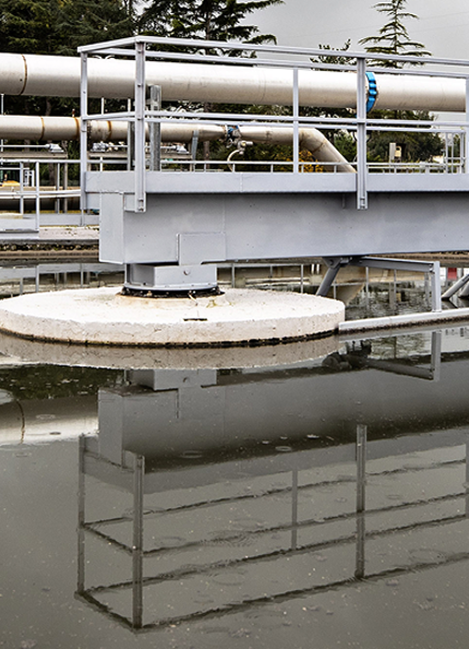 infrasturttura idrica Acea con una vasca piena d'acqua, delle strutture in ferro e gli alberi sullo sfondo