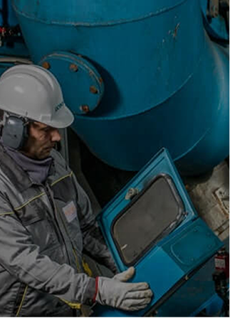 operaio Acea che fa delle prove su una cabina elettrica e ha sullo sfondo un grosso tubo azzurro